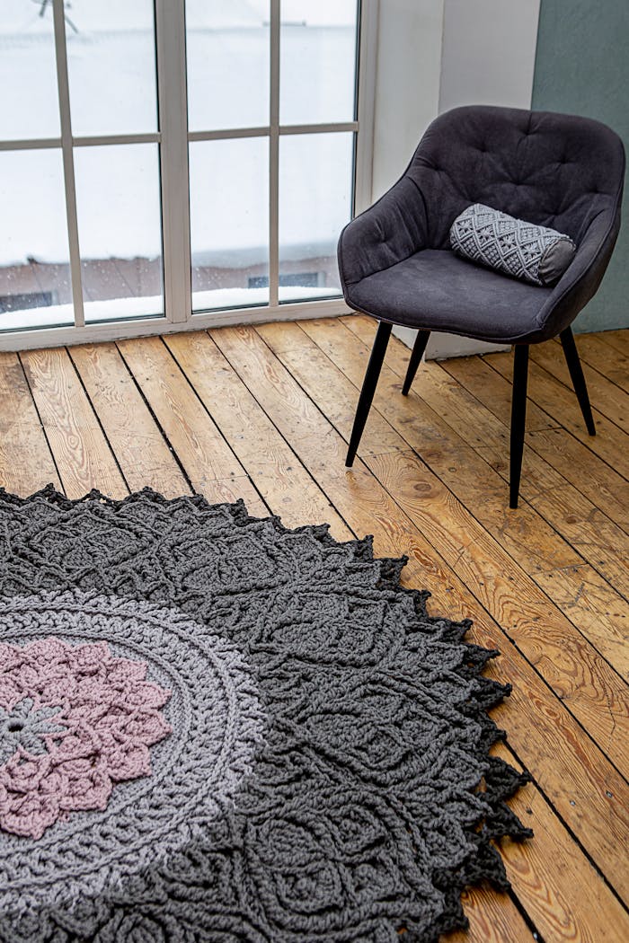 Elegant room showcasing a handmade crochet rug and stylish chair by the window.