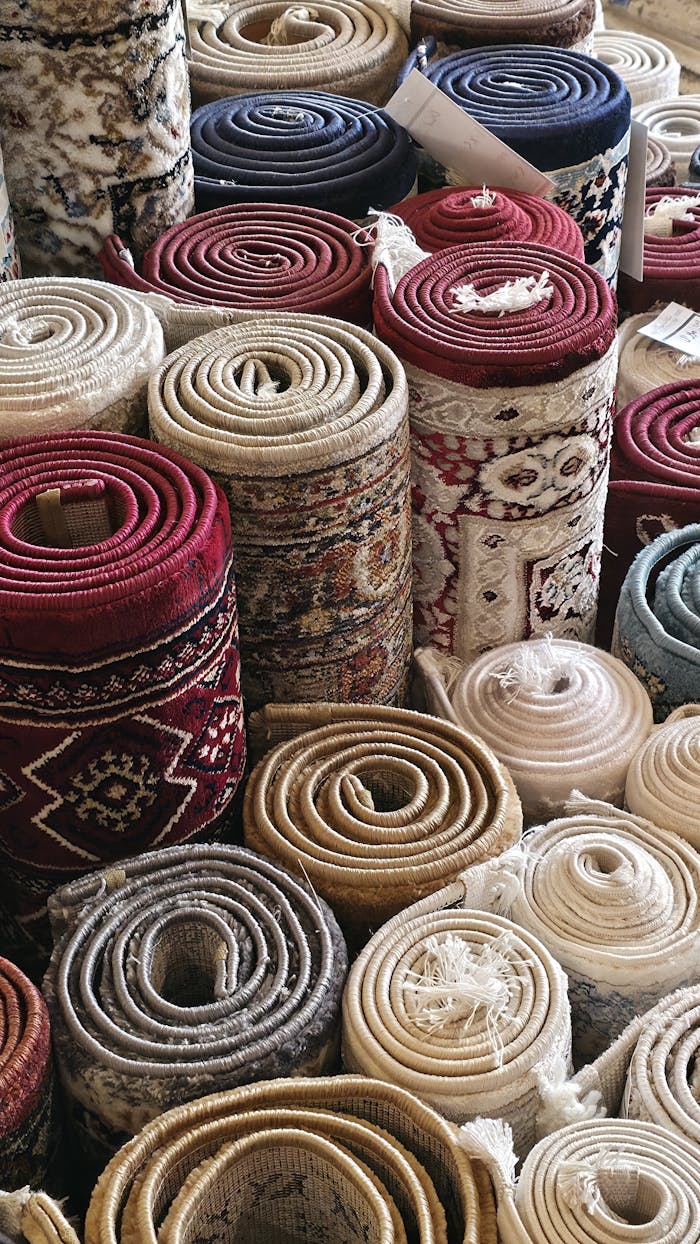 Vibrant rolled carpets showcased in Jeddah's traditional market. Perfect for home decor shopping.